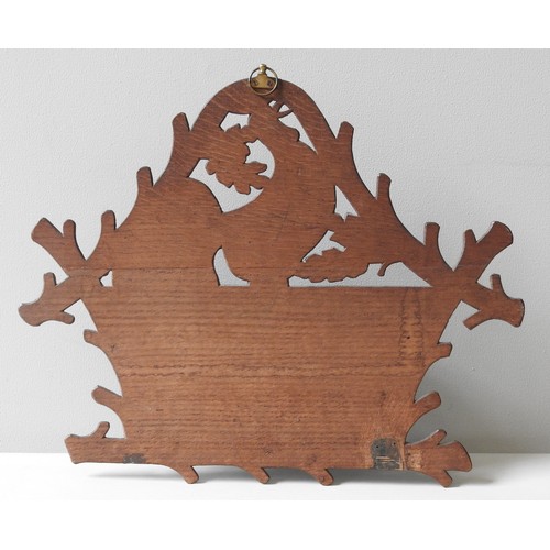 379 - A CARVED BLACK FOREST WALL MOUNTED RACK, EARLY 20TH CENTURY, the back panel carved with the image of... 