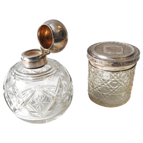 320 - A CUT GLASS SILVER TOP SCENT BOTTLE AND CUT GLASS POT WITH SILVER COVER, CIRCA 1910, globular form s... 