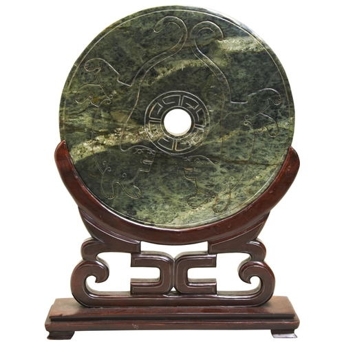 313 - A LARGE GREEN HARDSTONE ARCHAISTIC BI-DISC AND STANDQING DYNASTYcarved with lions and calligraphic c... 