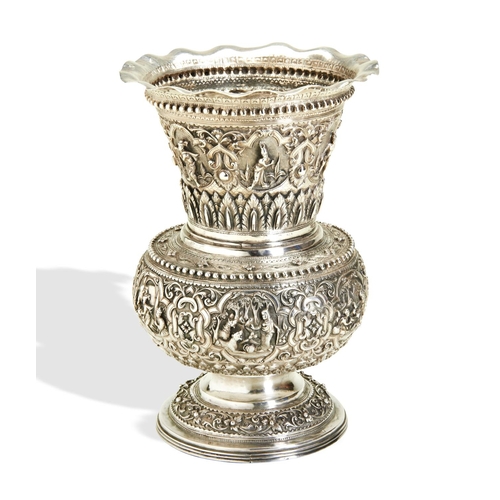 140 - A BURMESE SILVER VASE C.1880. A campana shape vase chased all over with fine detailed scenes and str... 