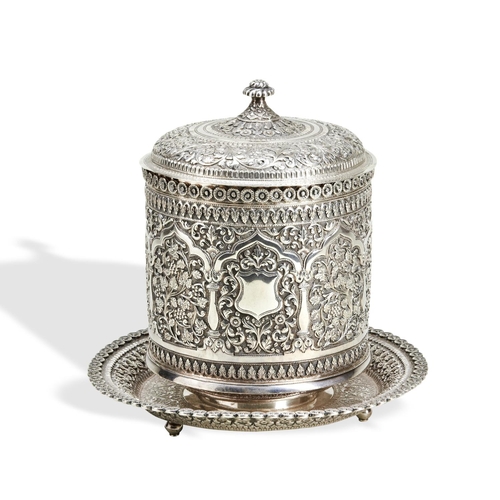 144 - A KUTCH SILVER BISCUIT BOX C.1890. The jar has an integral base and lift off lid. The reserves aroun... 