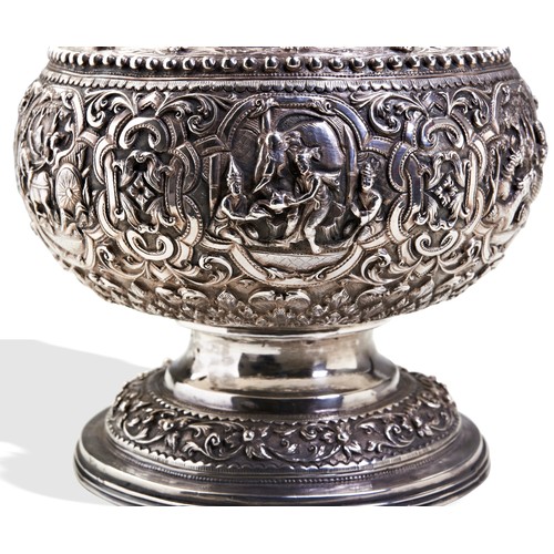 140 - A BURMESE SILVER VASE C.1880. A campana shape vase chased all over with fine detailed scenes and str... 