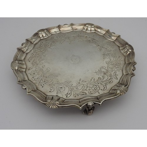 254 - A GEORGE III SILVER SALVER, circular form with scroll edge, with blossoming stems chased decoration ... 