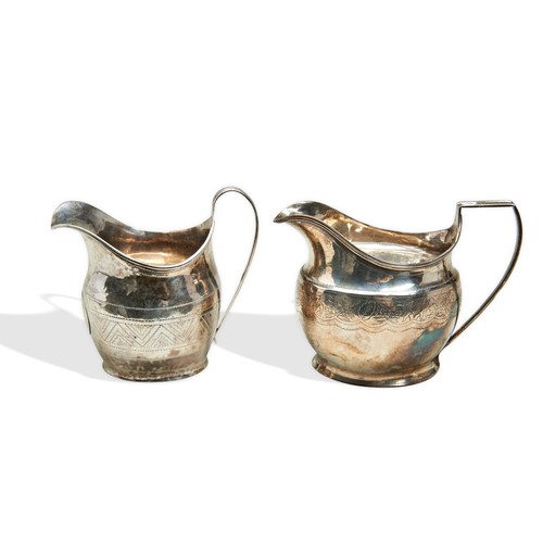 284 - TWO GEORGE III SILVER CREAM JUGS, helmet form with bright cut waist decoration, rubbed maker's marks... 