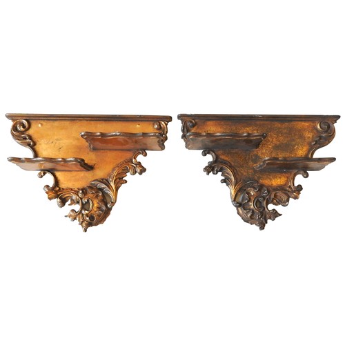 97 - A PAIR OF ITALIAN STYLE GILT WOOD WALL BRACKETS, EARLY 20TH CENTURY, split level shelves mounted on ... 