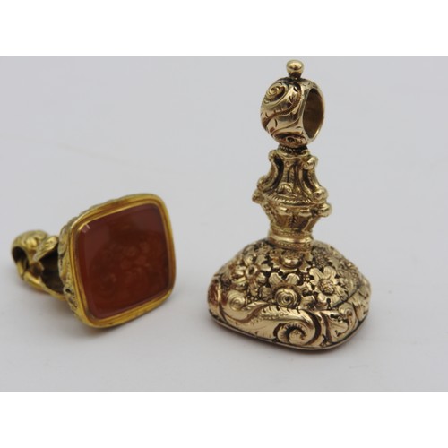 364 - AN ORNATE GOLD INTAGLIO FOB SEAL AND A GOLD FILLED CORNELIAN FOB, the large fancy gold fob with prof... 