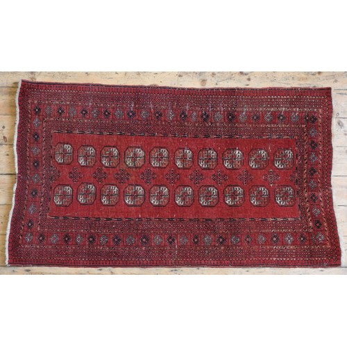 74 - A HAND KNOTTED BOKHARA RUG, 20TH CENTURY, deep border pattern on a red ground182 x 105 cm