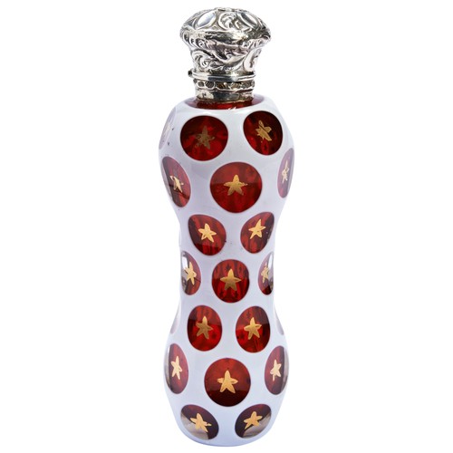 123 - A BOHEMIAN WHITE AND RUBY CASED GLASS SCENT BOTTLE, cut with oval roundels pointed with gold stars, ... 