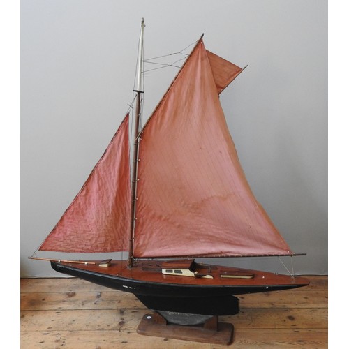 86 - A LARGE VINTAGE POND YACHT, EARLY 20TH CENTURY, with mast, booms, twin sails, a mahogany deck and a ... 