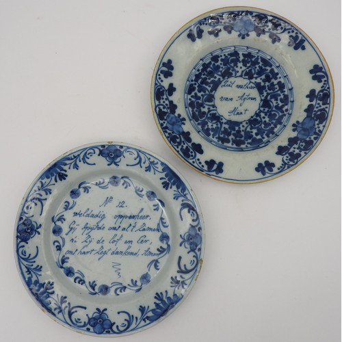 127 - TWO EARLY 19TH CENTURY DELFT BLUE & WHITE PLATES, one with a central inscription with scrolling ... 