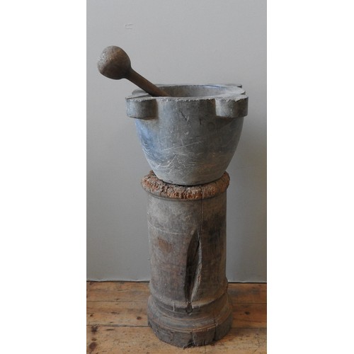 83 - A LARGE 18TH CENTURY GREY MARBLE MORTAR ON TURNED WOODEN COLUMN STAND, with substantial woodeN pestl... 