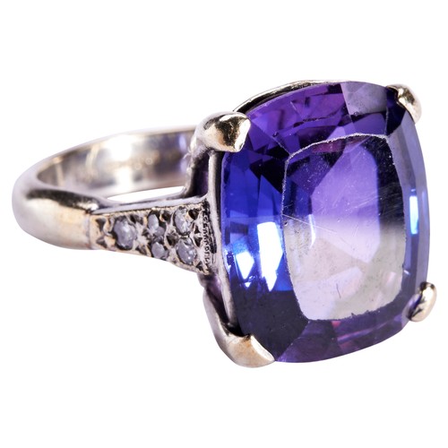 260 - A SYNTHETIC COLOUR CHANGE CORUNDUM AND DIAMOND RINGthe cushion-cut stone four claw set above pierced... 