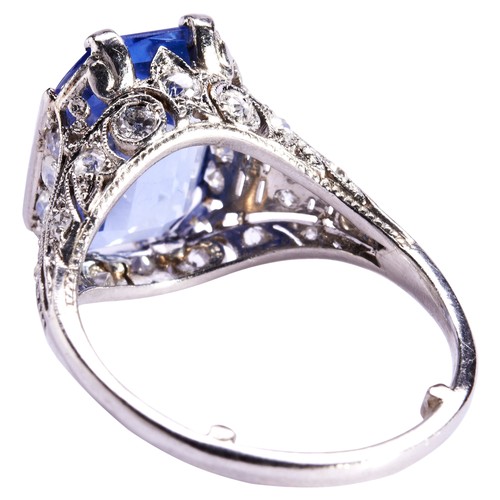 303 - A SAPPHIRE AND DIAMOND RING, CIRCA 1920the emerald-cut, cut cornered sapphire four claw, set above a... 