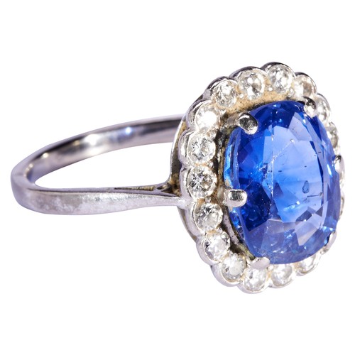 305 - A SAPPHIRE AND DIAMOND RING, CIRCA 1930the cushion cut sapphire six claw set within a border of eigh... 