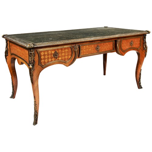 A FRENCH LOUIS XV STYLE 19TH CENTURY BUREAU PLAT, the leather inset top with ormolu border, the three drawers with parquetry chequered decoration, opposed by three faux drawers all with ormolu mounted borders, the curved legs with ormolu knees and feet and used by Lew Grade in his home office.