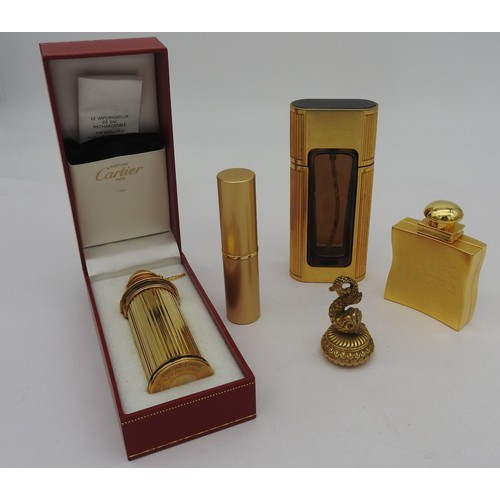 654 - A GROUP OF FIVE PERFUME BOTTLES, including two Cartier atomisers, a Hermes atomiser modelled as a hi... 