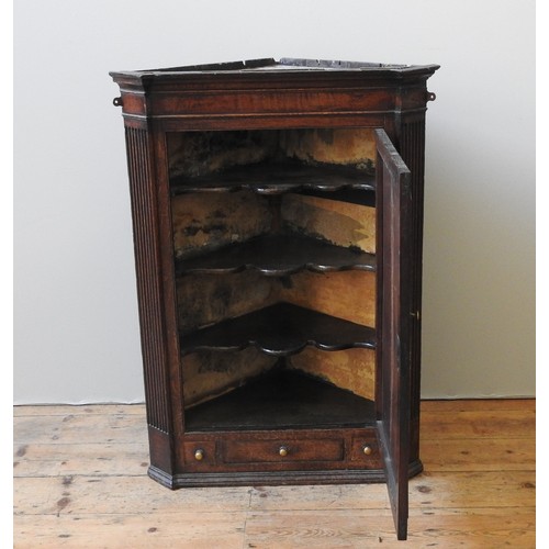 1 - A 19TH CENTURY OAK CORNER CUPBOARD, a single panelled door enclosing three interior shelves, the doo... 