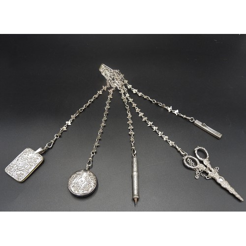 827 - AN ORNATE LATE VICTORIAN SILVER CHATELAINE, pierced armorial clip supporting five foliate link chain... 