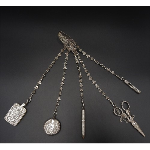 827 - AN ORNATE LATE VICTORIAN SILVER CHATELAINE, pierced armorial clip supporting five foliate link chain... 