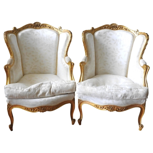 90 - A PAIR OF LOUIS XV STYLE CARVED GILTWOOD AND UPHOLSTERED FAUTEUILS, 20TH CENTURY, wing back form cov... 