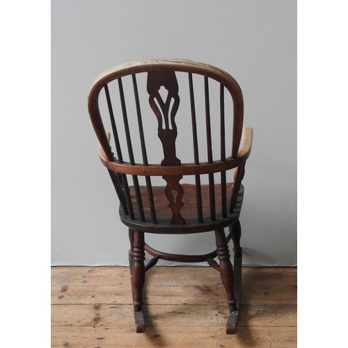 63 - A WINDSOR ROCKING CHAIR, 19TH CENTURY, with a pierced splat over an elm saddle seat, raised on four ... 