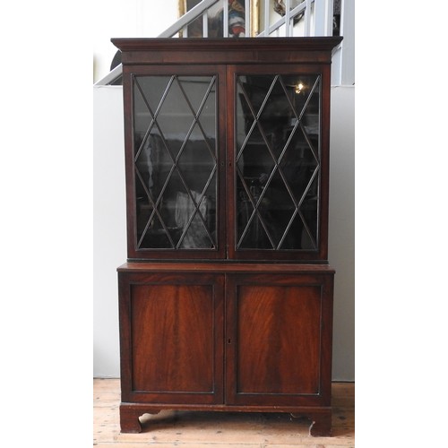 43 - A GEORGE III MAHOGANY BRACKET FOOT BOOKCASE CUPBOARD, CIRCA 1820, in two sections, the top section c... 