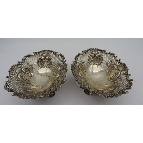 828 - A PAIR OF LATE VICTORIAN SILVER BON BON DISHES, oval form, ornate pierced trellis work sides with ch... 