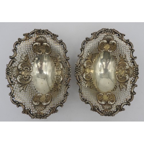 828 - A PAIR OF LATE VICTORIAN SILVER BON BON DISHES, oval form, ornate pierced trellis work sides with ch... 