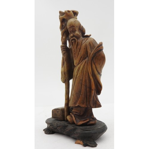 321 - A SMALL SOAPSTONE FIGURE OF SHULAO, 20TH CENTURY, modelled in robed attire holding a tree root staff... 