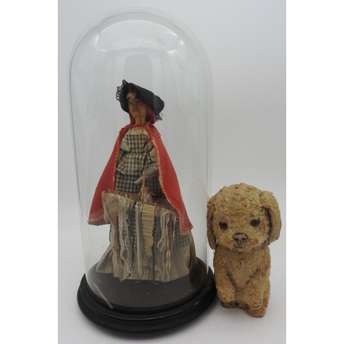 235 - A PEDDLAR DOLL UNDER A GLASS DOME AND A VINTAGE PLUSH DOG WITH A BARKING ACTION.dome 35cm high x 35c... 