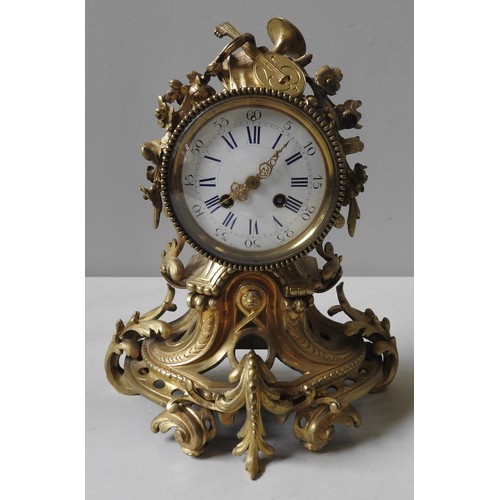 253 - A ORNATE FRENCH BRASS MANTEL CLOCK, LATE 19TH CENTURY, the gilt brass cased surmounted by musical in... 