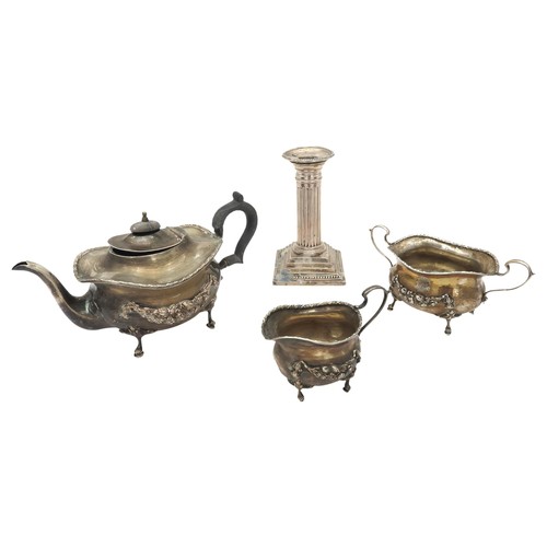 842 - A SILVER TEA SET AND WEIGHTED CANDLESTICK, the boat form tea three-piece tea set decorated with chas... 