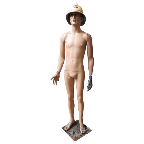 653 - A VINTAGE SHOP MANNEQUIN, CIRCA 1975, wearing a vintage fireman's helmet, fixed to a square metal ba... 