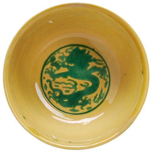 4 - A GREEN AND YELLOW ENAMELLED 'DRAGON' BOWLKANGXI SIX CHARACTER MARK AND PERIOD康熙黃底綠龍紋盌 resting on a ... 