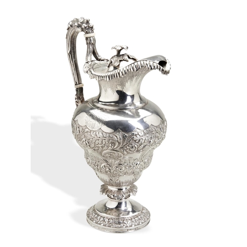 125 - AN ANGLO-INDIAN CLARET JUG C.1860. A double baluster shape claret jug, heavily embossed and chased w... 