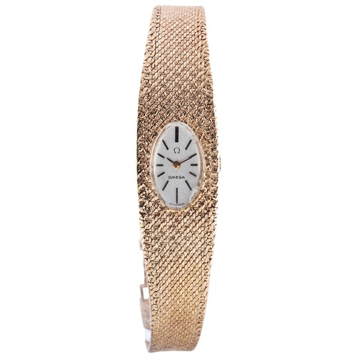 436 - AN OMEGA 9 CARAT GOLD LADIES WRISTWATCHoval silvered dial on integral  flexible bark-finished bracel... 