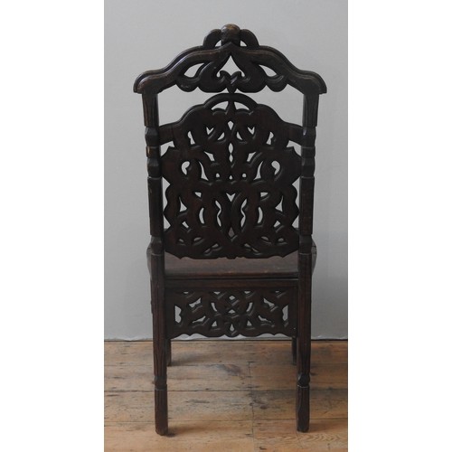 33 - A CONTINENTAL OAK HALL CHAIR, LATE 18TH/EARLY 19TH CENTURY, the arch top rail with carved mask decor... 