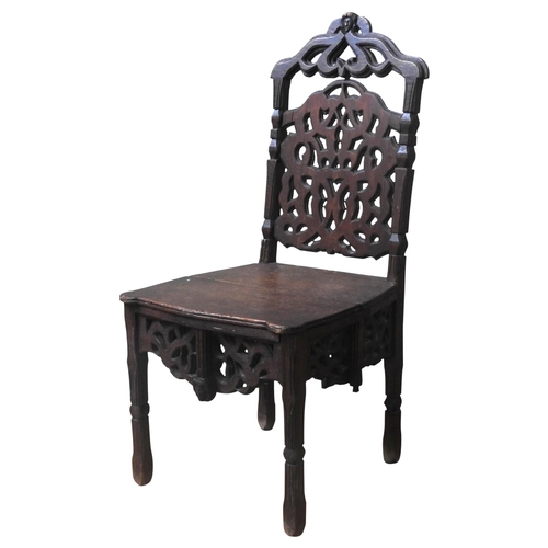 33 - A CONTINENTAL OAK HALL CHAIR, LATE 18TH/EARLY 19TH CENTURY, the arch top rail with carved mask decor... 