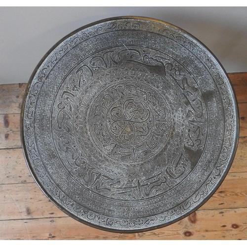 24 - A VINTAGE QADJAR BRASS TRAY / TABLE TOP, profusely decorated with patterned concentric bands, raised... 