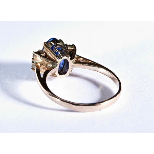 411 - A SAPPHIRE RINGthe oval mixed-cut sapphire, claw set between pairs of white stones.Ring size G... 