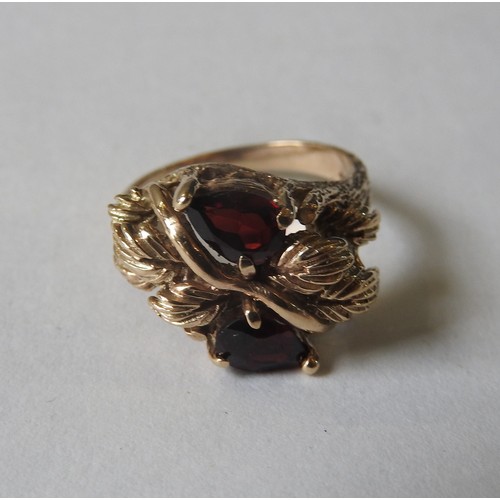 407 - AN UNUSUAL GARNET MOUNTED GOLD RING, the two pear shaped garnets set in a foliate decorated mount, t... 