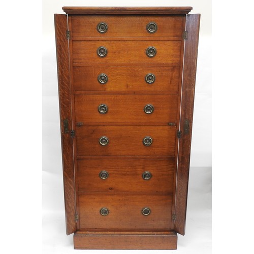 93 - A VICTORIAN OAK WELLINGTON CHEST, comprised of seven graduated drawers with hinged locking stiles, r... 