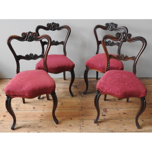 76 - A SET OF FOUR VICTORIAN MAHOGANY BALLOON BACK CHAIRS, ornate floral and scroll carved frames, raised... 