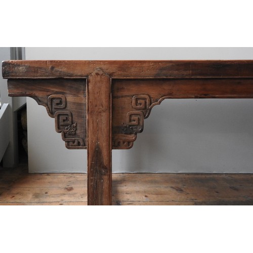 85 - A CHINESE KANG DINING TABLE, rectangular top raised on twin trestle ends, with carved angle brackets... 