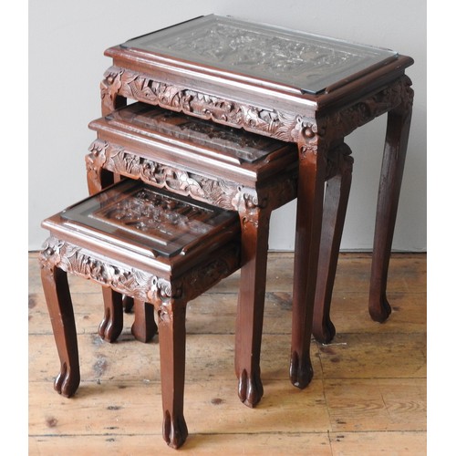 81 - A NEST OF THREE CHINESE HARDWOOD TABLES, LATE 20TH CENTURY, the rectangular tops carved in high reli... 