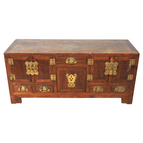 82 - A CHINESE HARDWOOD LOW SIDE CABINET, simple rectangular form, the central cupboard door and frieze d... 