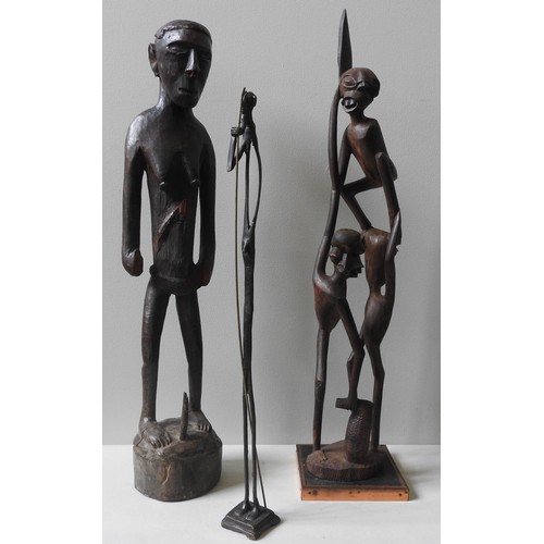 242 - A CARVED PAPUA ASMAT FIGURE AND A CARVED MAKONDE GROUP FIGURE, along with a slender bronze figure68 ... 