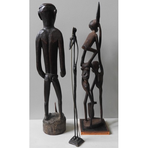 242 - A CARVED PAPUA ASMAT FIGURE AND A CARVED MAKONDE GROUP FIGURE, along with a slender bronze figure68 ... 