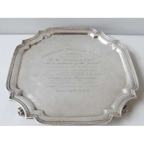 548 - A VINTAGE SILVER SALVER, square form with scroll edge raised on four scrolling feet, marked Birmingh... 