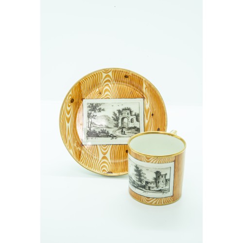 811 - A VIENNA 'FAUX BOIS' CUP AND SAUCERCIRCA 1790Decorated with faux bois ground and tromp l'oeil landsc... 